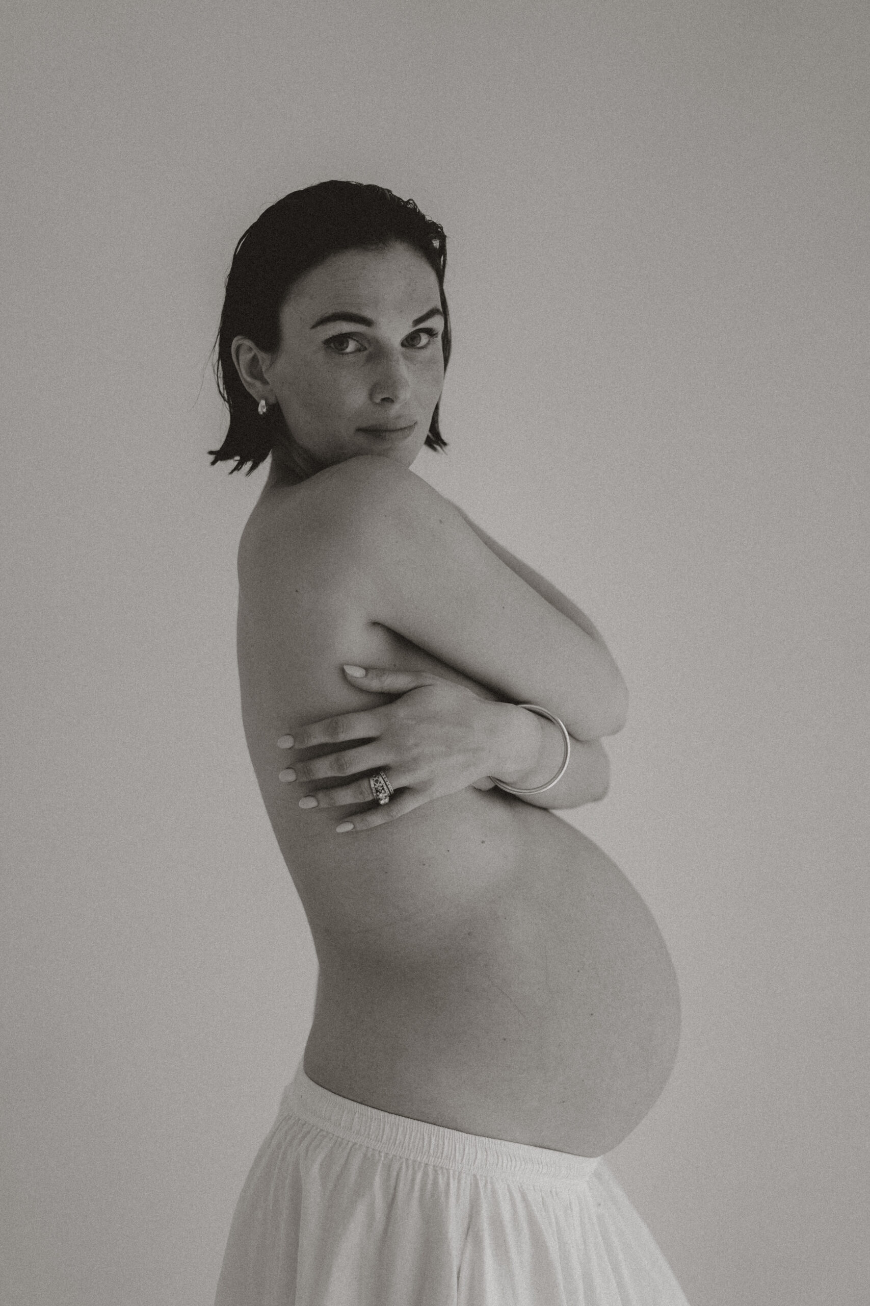 Black and white images of woman holding bump